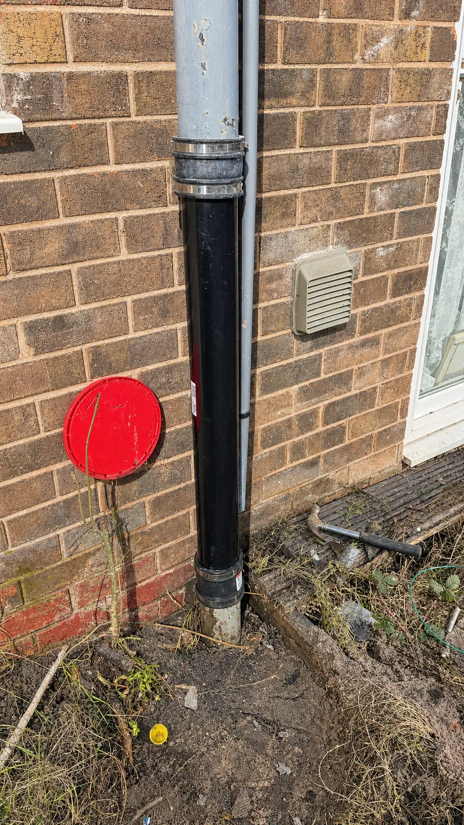 Replacement rainwater downpipe fitted to the outside of a house in Oldham