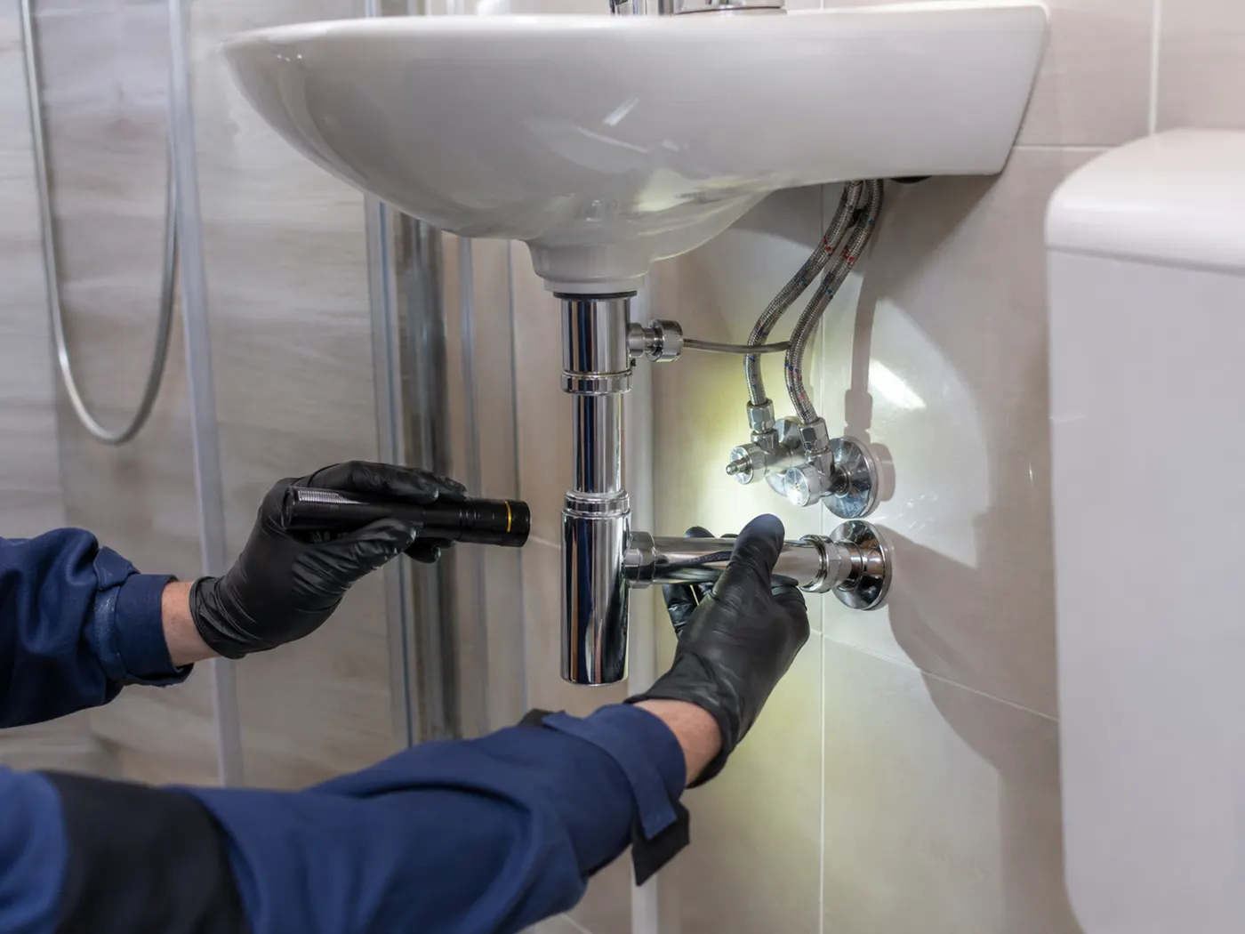 Plumber carrying out a plumbing maintenance check at a rental property in Greater Manchester